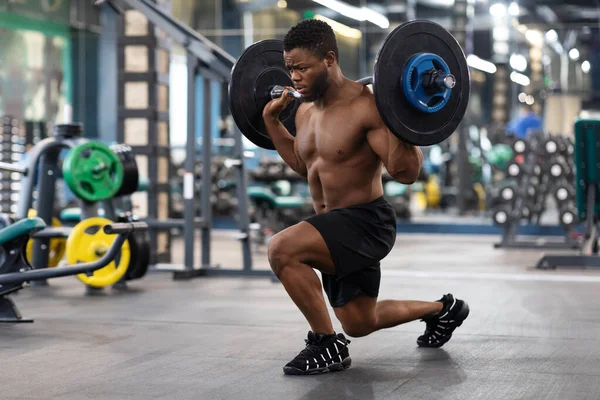Hemdloser schwarzer Kerl Sportler macht Kniebeugen mit Langhantel — Stockfoto