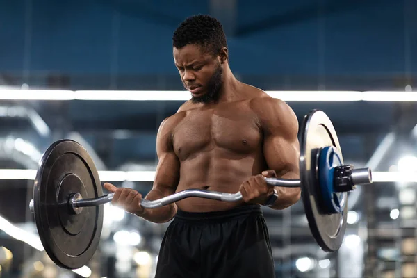 Nahaufnahme eines muskulösen Bodybuilders, der im Fitnessstudio mit der Langhantel trainiert — Stockfoto