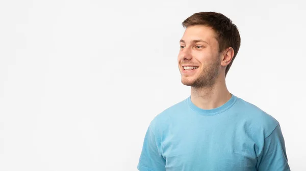 Lächelnder selbstbewusster Typ, der Kopierraum auf weißem Hintergrund betrachtet — Stockfoto