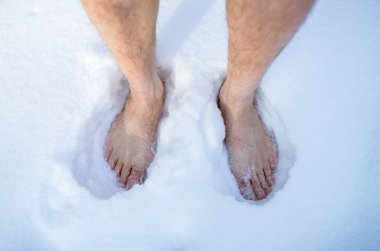 Top view of senior man on snow outdoors, closeup of feet. Unrecognizable guy developing resistance to cold in winter clipart