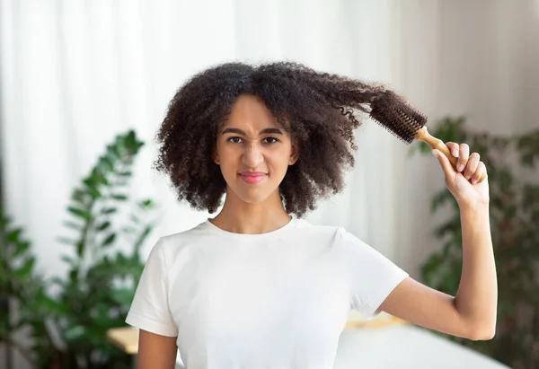 Wanita african yang tidak bahagia sikat kusut, rusak, rambut kering — Stok Foto