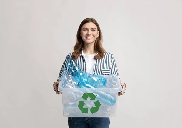 Plastová recyklace. Pozitivní Millennial žena držení kontejner s lahvemi pro recyklaci — Stock fotografie