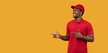 Gülümseyen siyah sakallı teslimatçı işaret ediyor