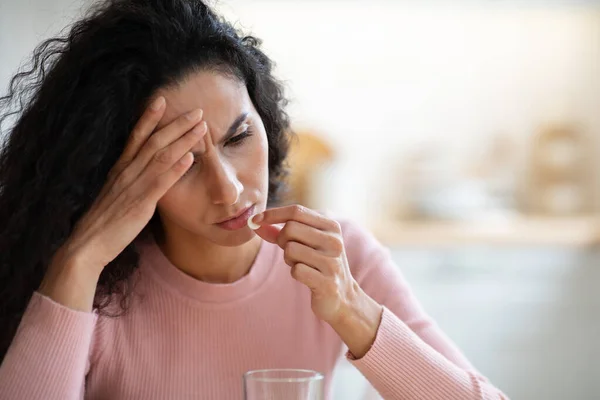Ideges fiatal nő vesz fájdalomcsillapítót, miközben szenved a fejfájás otthon — Stock Fotó