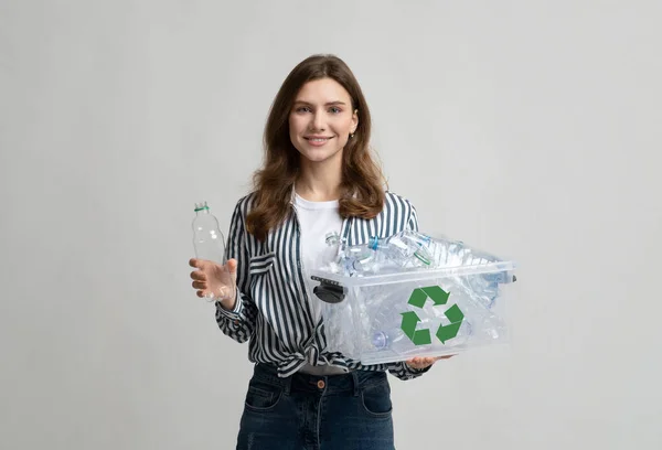 Plastik-Recycling. Lächelnde junge Frau sammelt Flaschen für das Abfallrecycling im Container — Stockfoto