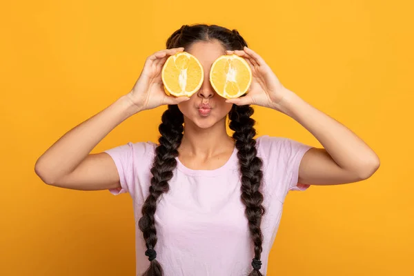 Senhora indiana cobrindo os olhos com metades de frutas cítricas laranja — Fotografia de Stock