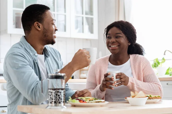Bonjour ensemble. romantique noir couple manger petit déjeuner et boire du café dans la cuisine — Photo