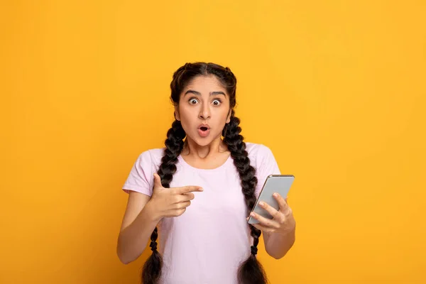 Opgewonden indiaanse vrouw met behulp van mobiele telefoon, wijzend op gadget — Stockfoto