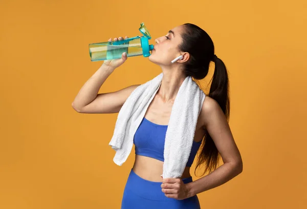 Deportiva mujer beber agua de la botella en el estudio — Foto de Stock