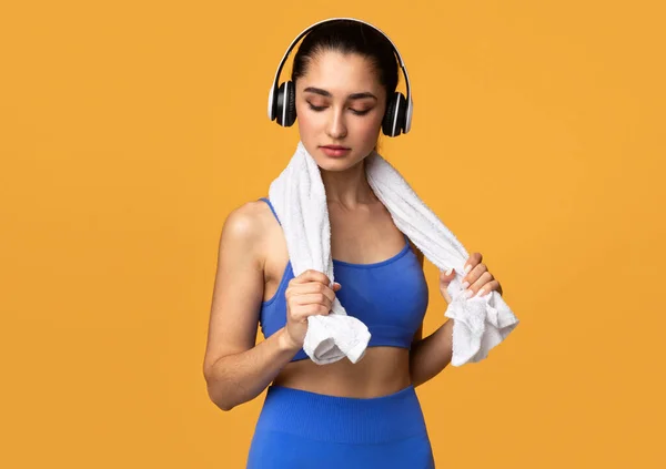 Mujer joven en ropa deportiva escuchando música en auriculares — Foto de Stock