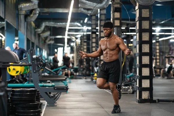 Sin camisa muscular negro chico saltar con saltar la cuerda en el gimnasio —  Fotos de Stock