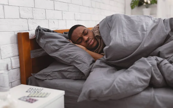 Hombre negro enfermo durmiendo en la cama teniendo gripe en casa — Foto de Stock