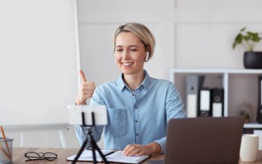 Çevrimiçi öğretmenlik. Profesyonel öğretmen öğrencilerle video görüşmesi yapıyor, işaret ediyor, evden ders veriyor.