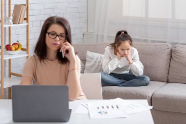 Evde internetten çalışan meşgul bir anne, yakınlardaki bir kanepede oturan ihmal edilmiş kız çocuğu, yalnızlık çekiyor.