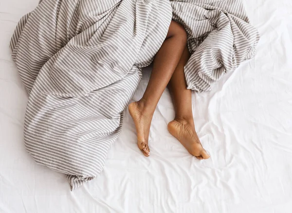 Тонкие, идеальные и красивые скрещенные женские ноги на кровати в отпуске и отпуске — стоковое фото