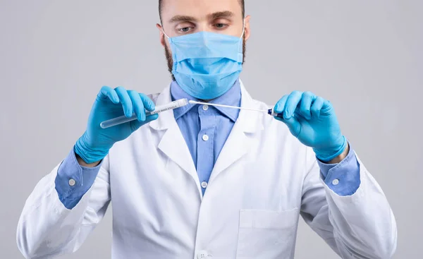 Médico en mascarilla facial y guantes que sostienen el tubo de ensayo covid-19 PCR sobre fondo de estudio gris claro, panorama —  Fotos de Stock