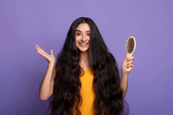 長い髪を持つ若いインド人女性の笑顔木製の櫛 — ストック写真