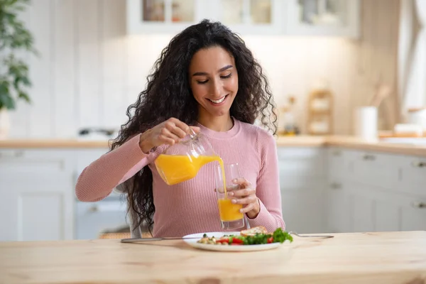 Glad tusenårig kvinna njuter av sin hälsosamma frukost i köket hemma — Stockfoto