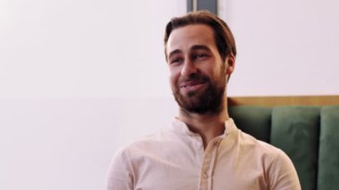 Neşeli, konuşkan, arkadaşlarıyla konuşan, şakalar yapan, kahkahalar atan, kafede oturan bir adamın yakın portresi.