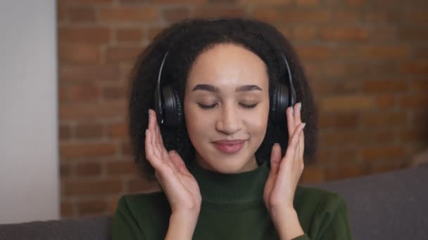 Close up retrato de mulher afro-americana relaxada desfrutando de música em fones de ouvido sem fio — Vídeo de Stock