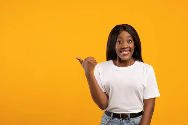 Mujer afroamericana positiva apuntando al espacio vacío — Foto de Stock