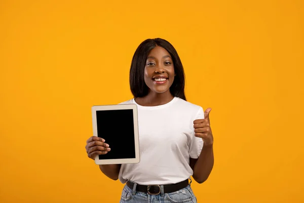Mujer bastante negra mostrando tableta digital con pantalla vacía — Foto de Stock