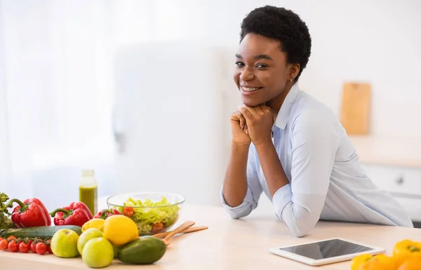 Negro mujer posando en cocina de pie cerca de mesa en casa — Foto de Stock