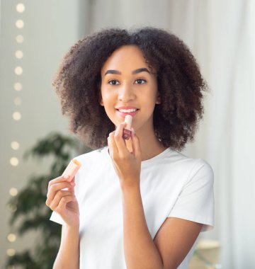 Kadın sabah makyajı için hazırlanıyor, balsam yapıyor, evdeki banyoya koyuyor.