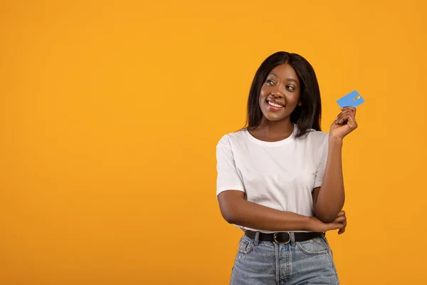 Sonriente mujer negra con tarjeta de crédito mirando el espacio de copia — Foto de Stock