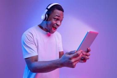 Çevrimiçi teklif. Kulaklıklı Siyah Adam Parlak Ekranlı Dijital Tablet Tutuyor