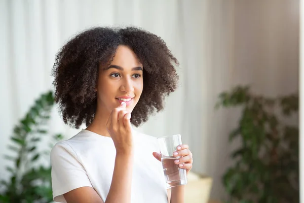 Happy tersenyum muda african american wanita minum pil atau vitamin dengan minyak hati cod omega-3 — Stok Foto