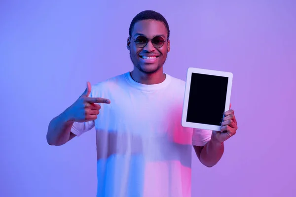 Wesoły czarny człowiek wskazując na pusty ekran tabletu cyfrowego, Neon Light, Mockup — Zdjęcie stockowe