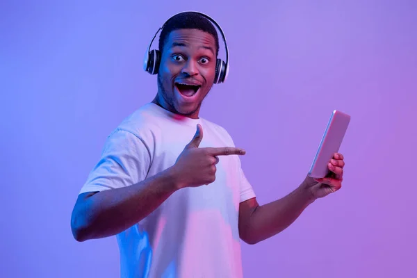 Gadgets modernos para entretenimiento. Hombre negro feliz en auriculares usando tableta digital —  Fotos de Stock