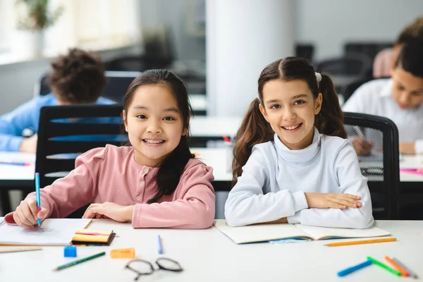 Kislányok portréja az osztályteremben az íróasztalnál — Stock Fotó