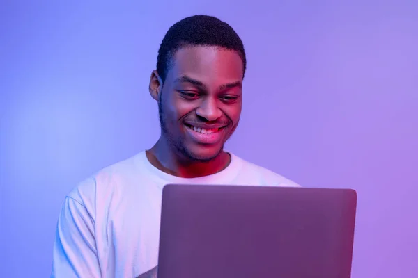 Jóképű mosolygós fekete programozó Guy dolgozik Online Laptop Neon Light — Stock Fotó