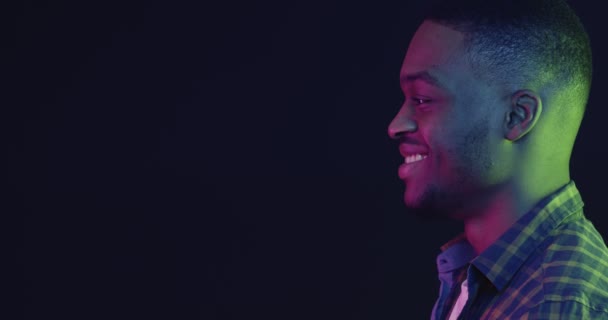 Potret profil pemuda kulit hitam yang melihat ruang fotokopi dan tersenyum, latar belakang lampu neon, ruang kosong untuk mockup — Stok Video