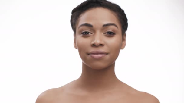 Young african american woman stepping forward to camera focus and smiling, white background — Stock Video