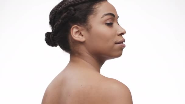 若いヌードアフリカ系アメリカ人女性のカメラと笑顔への転換のバックビュー,白いスタジオの背景 — ストック動画