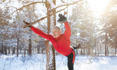 Spor giyim sektöründe kıdemli atletik adam kış günü dışarıda spor yapıyor. Spor salonunda spor yapıyor.