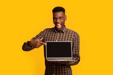 Şu siteyi kontrol et. Siyah ekranlı dizüstü bilgisayarı işaret eden Afrikalı adam