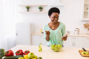 Modern Mutfakta Akıllı Telefon Kullanan Siyah Kadın Sebze Yiyen Salata