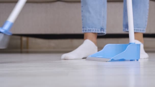 Huiselijke routine. close-up van vrouw vegen vloer thuis met bezem en primeur, slow motion — Stockvideo