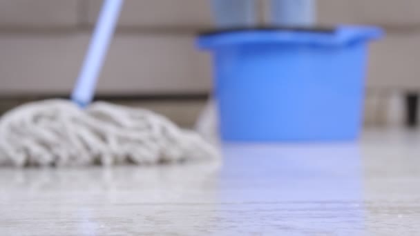 Blötläggning. Närbild av tvätt mopp rengöring golv hemma, suddig och fokuserad skott, slow motion — Stockvideo