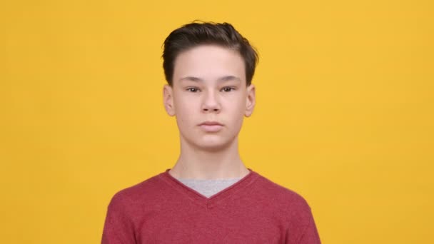 Calma adolescente menino meditando com os olhos fechados sobre fundo amarelo — Vídeo de Stock