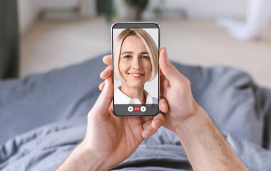 Tanımlanamayan genç adam karısıyla uzaktan konuşuyor, cep telefonuyla kız arkadaşıyla internette sohbet ediyor.