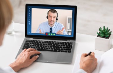 Uzak İş İletişimi. Kulaklıklı İşadamı Web Konferansı aracılığıyla İş Arkadaşlarıyla Konuşuyor