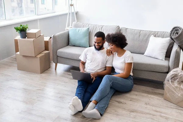 Afroamerikanisches Paar nutzt Laptop nach Einzug in neues Haus — Stockfoto