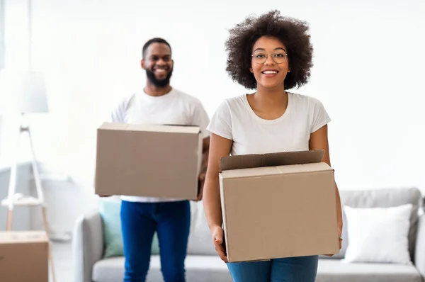 Casal preto em movimento transportando caixas de papelão embaladas para a nova casa — Fotografia de Stock