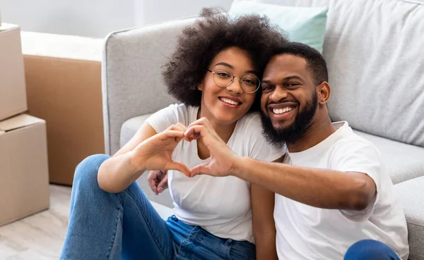 Couple Sitting Among Moving Boxes Gesturing Heart-Shape In New House — Stock Photo, Image