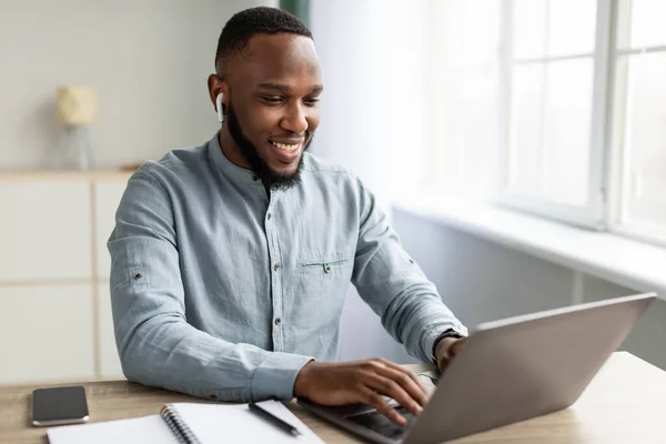 Udane African Businessman Praca na laptopie siedzi w nowoczesnym biurze — Zdjęcie stockowe